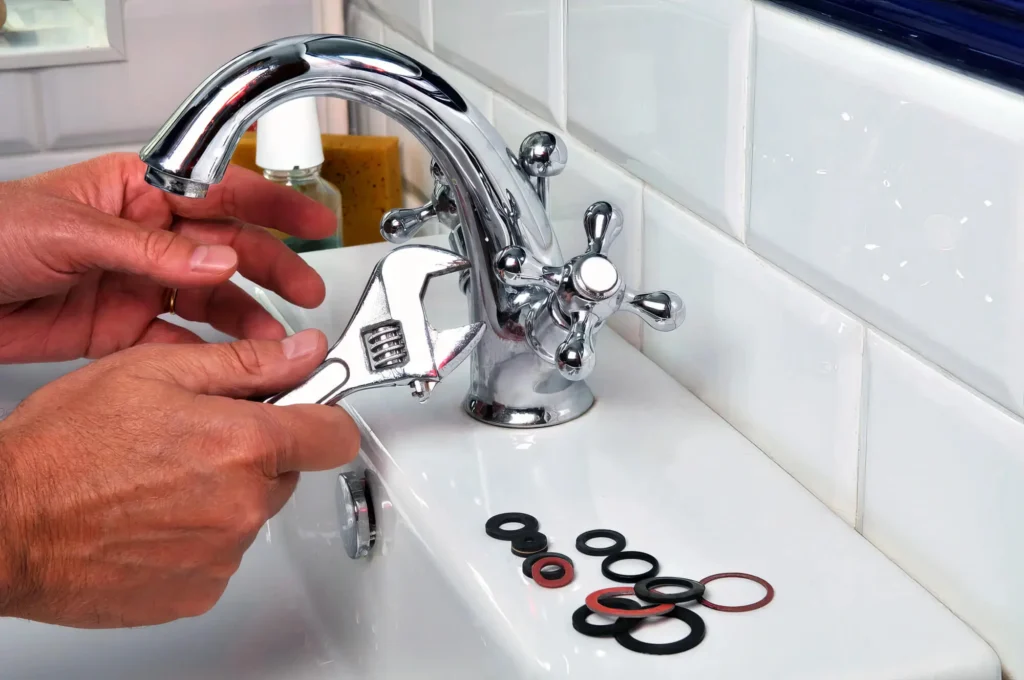 Plumber performing maintenance on a bathroom faucet in Fayetteville