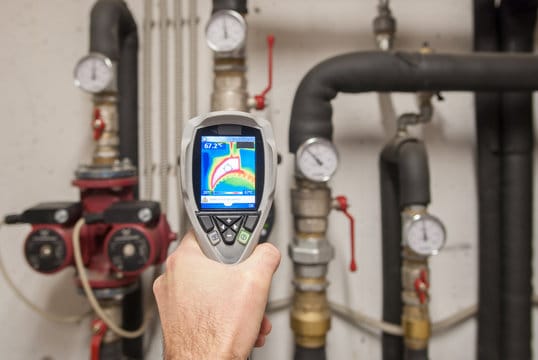 Plumber using a thermal imaging camera to inspect pipes in Fayetteville