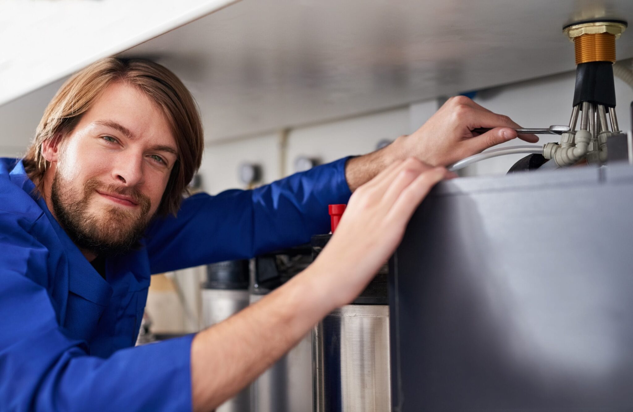 Technician servicing a residential water heater tank in Fayetteville